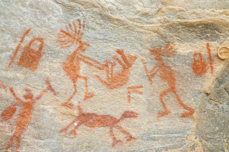 Smiling hands holding painted rocks with nature background